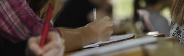 F6BB6E1E-C3A1-4D29-9486-37C6C938F9CC.jpeg Zwei Stifte in zwei Händen, die auf Blätter schreiben, die auf einem Tisch liegen