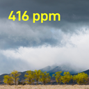 Landschaft mit trockenem Feld, Bäumen und Bergen im Hintergrund sowie dunklen Wolken am Himmel. Die Zahl „416 ppm“ ist grafisch hervorgehoben. 