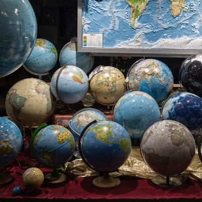 Schaufenster, in dem viele verschiedene Globen stehen