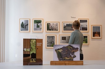 Eine Besucherin sieht sich Fotografien der Ausstellung Ogais Orte an