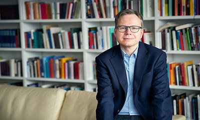Reckwitz Andreas 0154 Andreas Reckwitz sitzt auf einer Couch vor einem weißen Regal mit Büchern