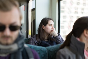 Studentin in der S-Bahn aus dem Fenster schauend