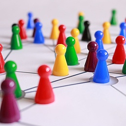 Colorful game pieces on a network diagram, symbolizing connectivity and teamwork.
