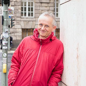 Prof. Dr. Geert Keil Prof. Dr. Geert Keil lehnt an einer Häuserwand an einer Straßenecke in Berlin.