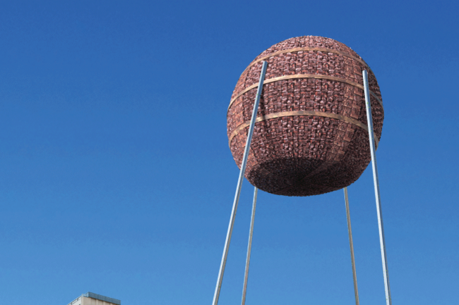 Matters of Activity Ein Objekt aus Rinde, überlebensgroß, steht auf Stelzen am Strausberger Platz in Berlin