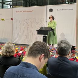 The president of HU gives a speech on stage in front of an audience.