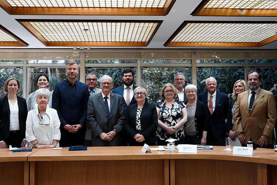Photo of a group of adults sitting behind a table.