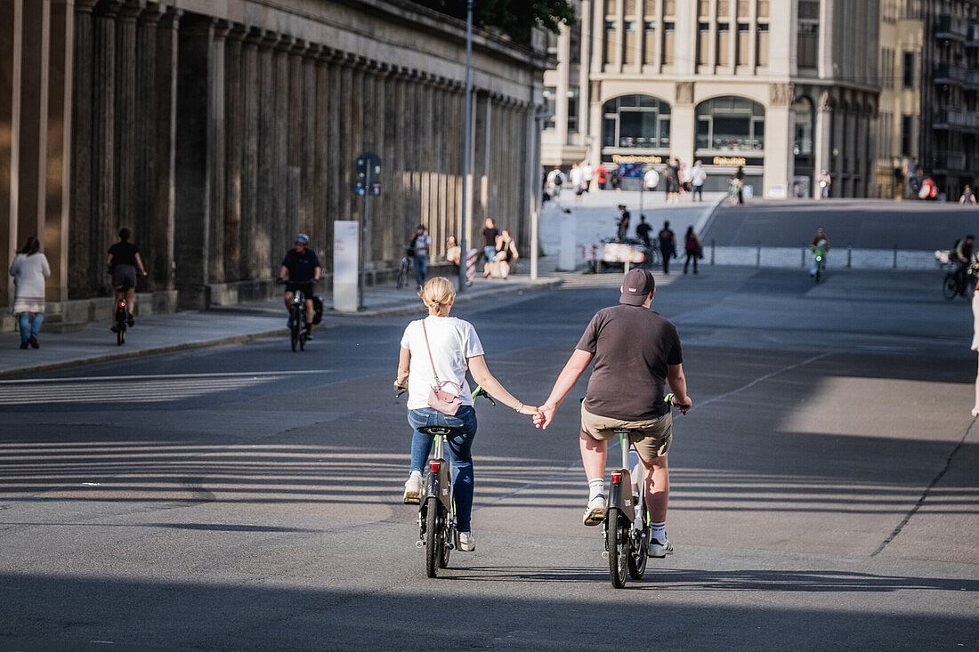 Ein Paar auf Fahrrädern in Berlin-Mitte Berlin Mitte. Ein Pärchen fährt Fahrrad und hält sich dabei an den Händen.