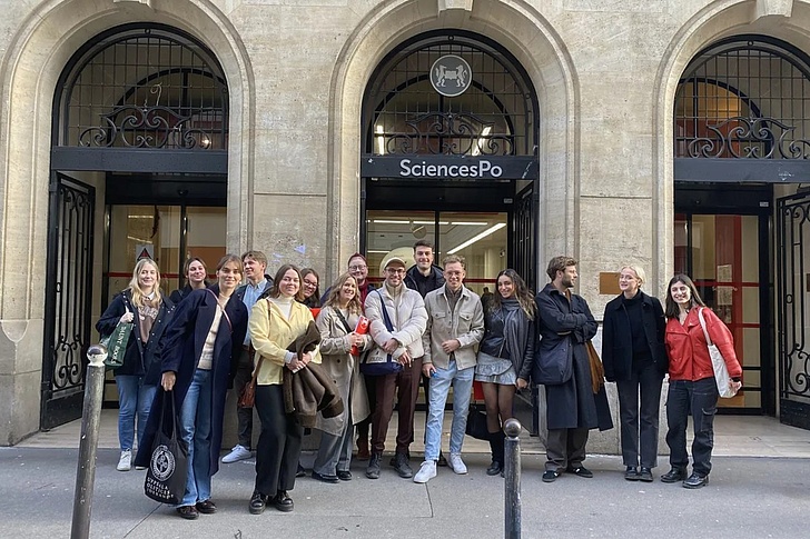 Gruppe von Menschen steht vor dem Eingang eines Gebäudes mit dem Schild 'SciencesPo'