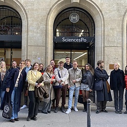 Gruppe von Menschen steht vor dem Eingang eines Gebäudes mit dem Schild 'SciencesPo'