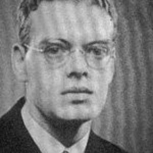 Black and white photograph by Gerd Tobias Schloss. He wears round glasses and looks seriously into the camera.