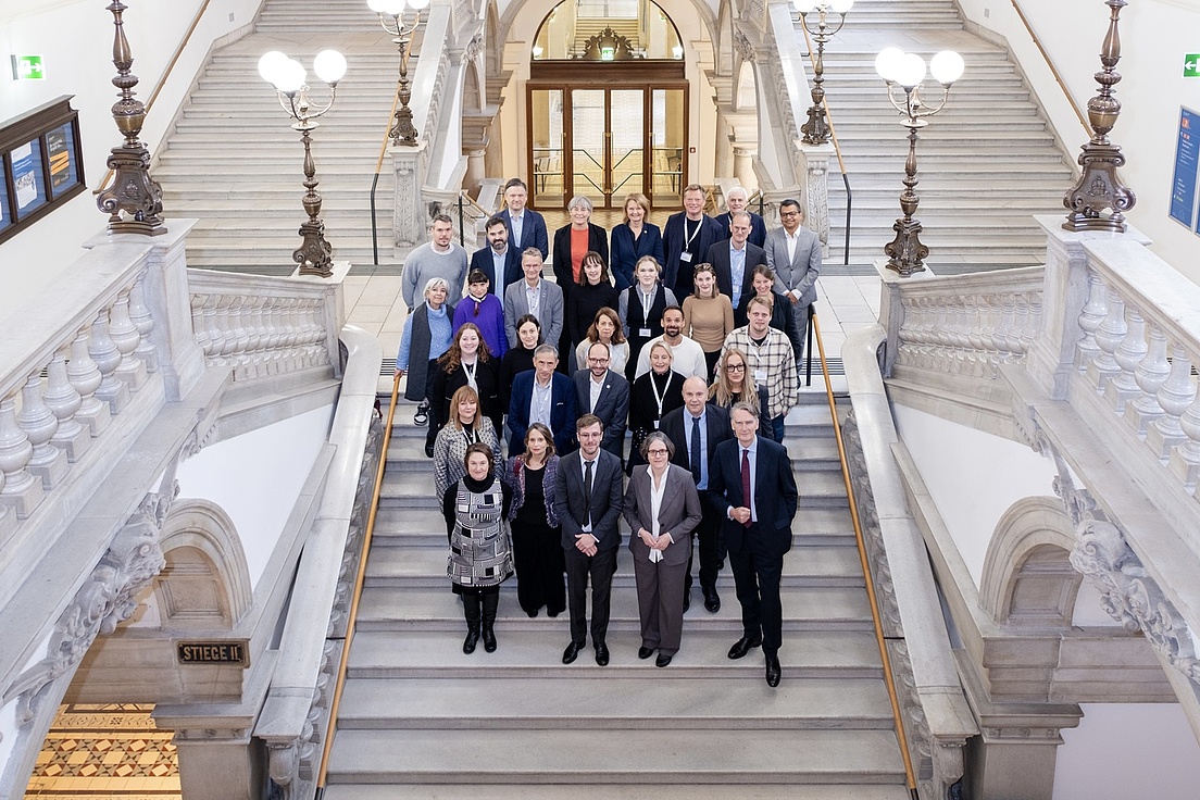 Photo of a group of people on the steps of a Baroque building