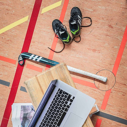 Familienfreundliche Universität Laptop, Zeitung, Notizbuch und Sportgeräte in einer Sporthallte