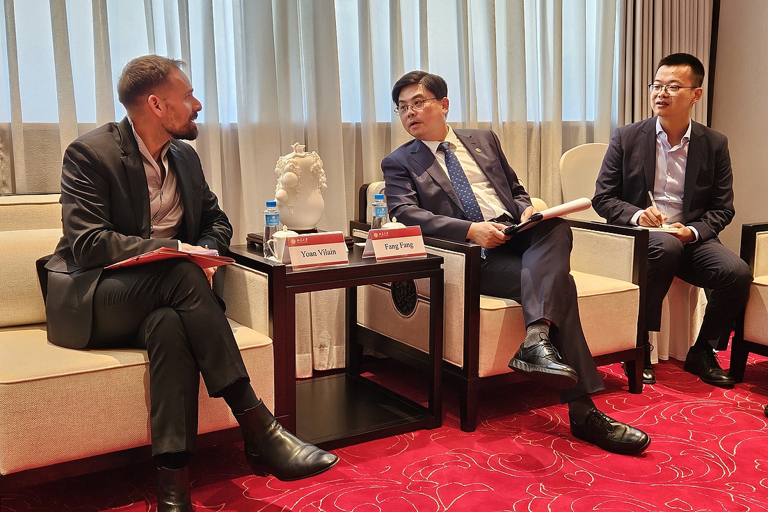 3 gesessene Männer reden zusammen.