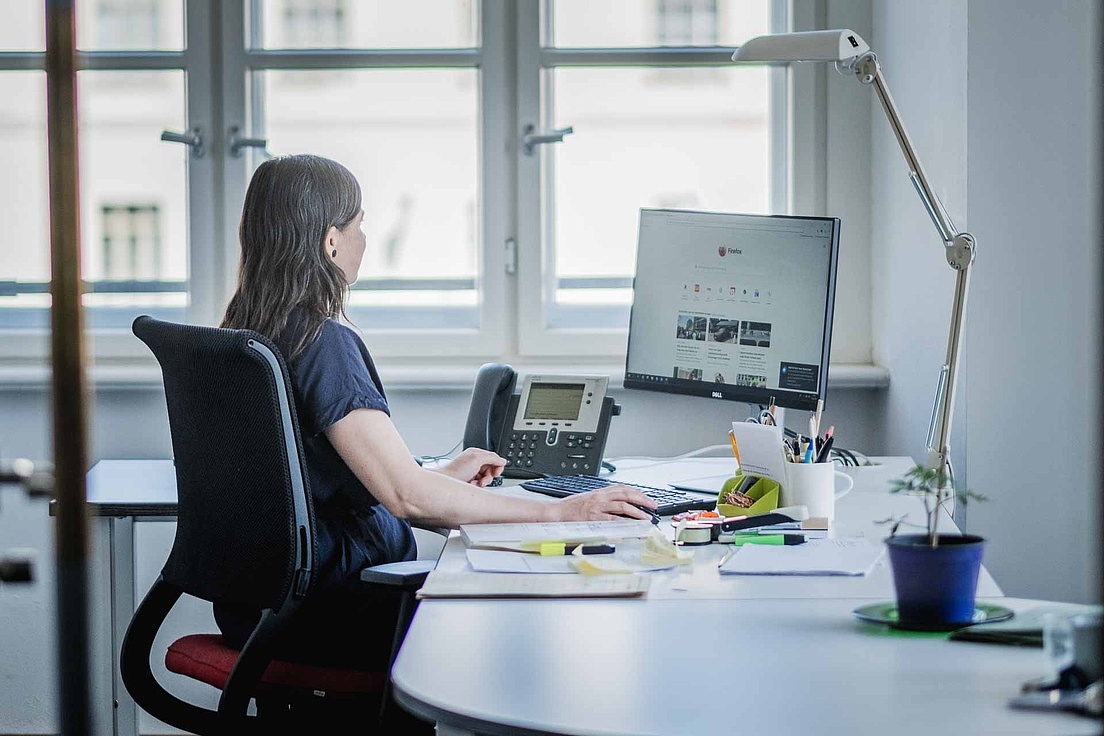 Ein Frau arbeitet an einem Computer in einem Büro an der HU Berlin.