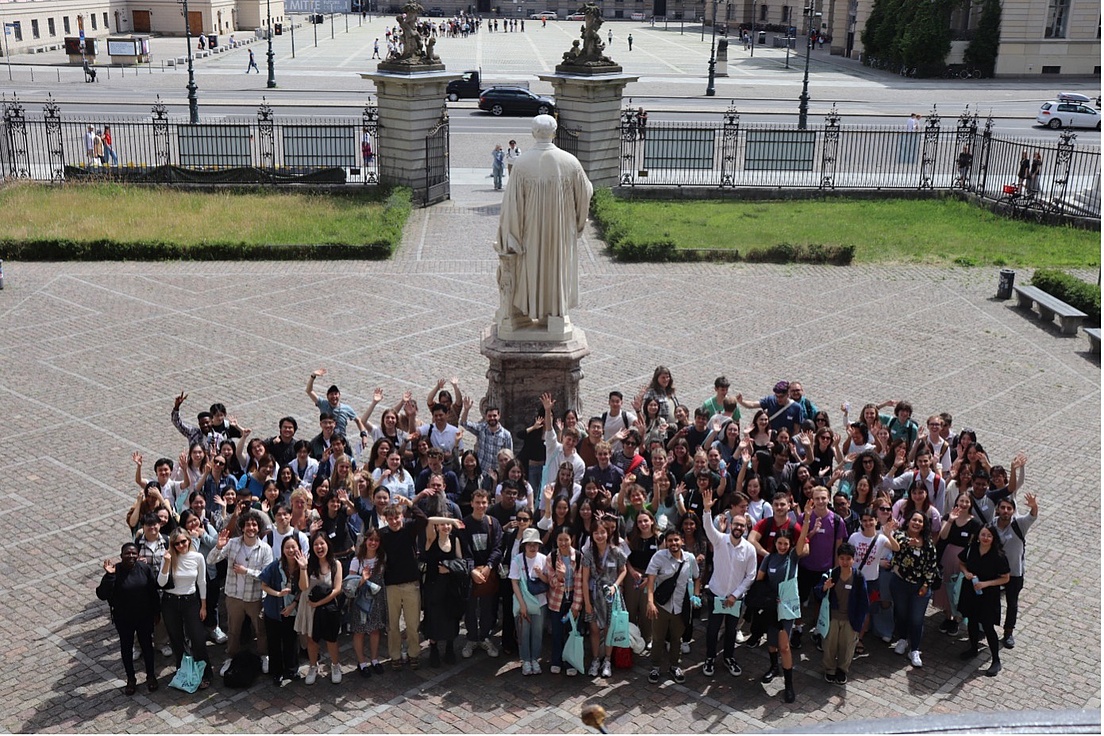 Eine Gruppe von Personen versammelt sich auf dem Hauptplatz des Hauptgebäudes der HU.