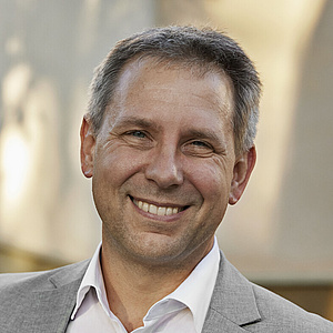 Porträt von Prof. Dr. Niels Pinkwart - Vizepräsident für Studium und Lehre an der HU Porträt von Prof. Dr. Niels Pinkwart - Vizepräsident für Studium und Lehre an der HU. Herr Pinkwart steht lächelnd vor einem HU-Gebäude