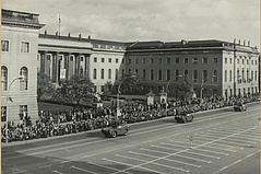 Ehrenparade vor dem Hauptgebäude zum 50. Jahrestag der Oktoberrevolution Eine Schwarzweiß-Aufnahme des HU-Hauptgebäudes vor dem Zuschauermassen stehen die vorbeifahrende Panzerfahrzeuge anschauen.