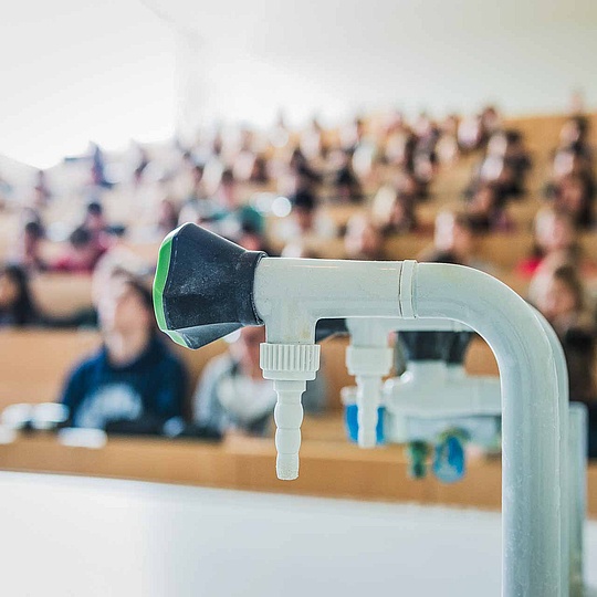 Wasserhahn im Hörsaal Nahaufnahme eines Wasserhahns in einem vollbesetzten Hörsaal der HU Berlin