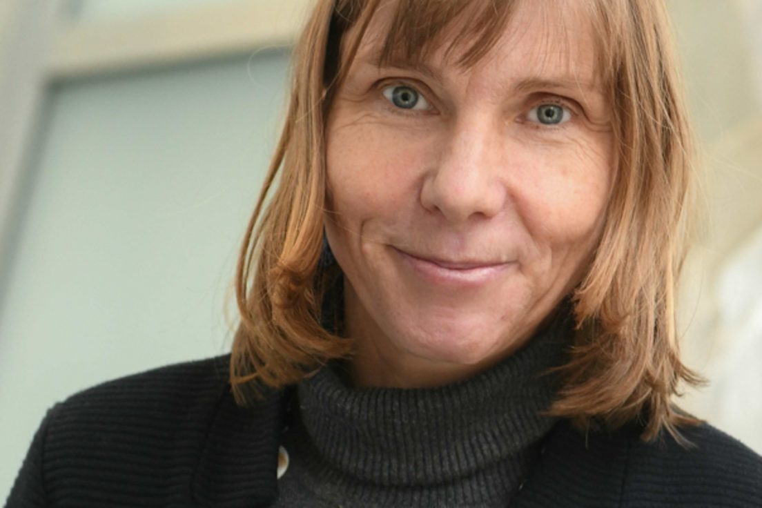 Tobia Lakes Tobia Lakes steht vor einem Fenster. Sie trägt einen grauen Rollkragenpullover und eine schwarze Jacke.