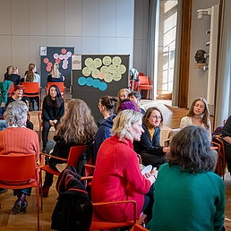 Teilnehmer*innen der Frauenvollversammlung 2025 sitzen in Kleingruppen und sprechen über das Workshopthema.