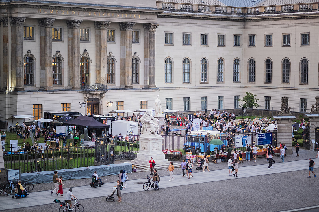Menschen und Stände im Ehrenhof des Hauptgebäudes der HU bei der Langen Nacht der Wissenschaften