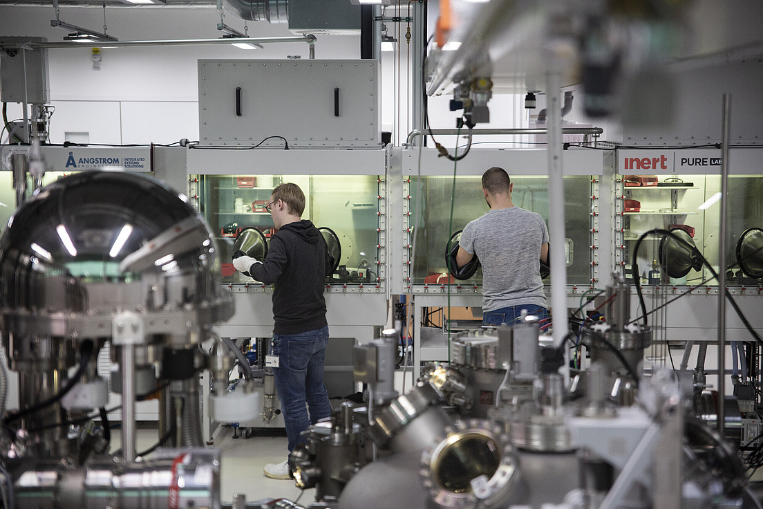 Mitarbeiter im Forschungslabor des Center of Science of Materials Berlin (CSMB) Zwei Männer arbeiten in einem Raum voller technischer Versuchsgeräte des CSMB der HU.