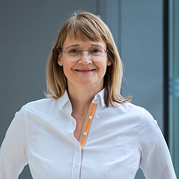 Beatrice Lugger Beatrice Lugger in weißem Hemd mit Brille schaut direkt in die Kamera