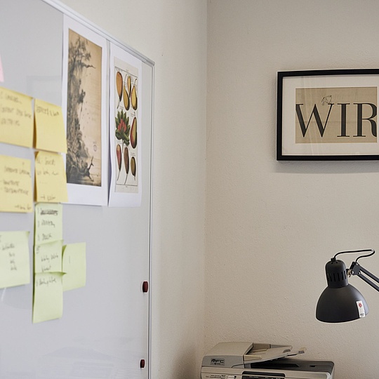 Desk with a lamp, a frame with the inscription "We" and Post-it notes.