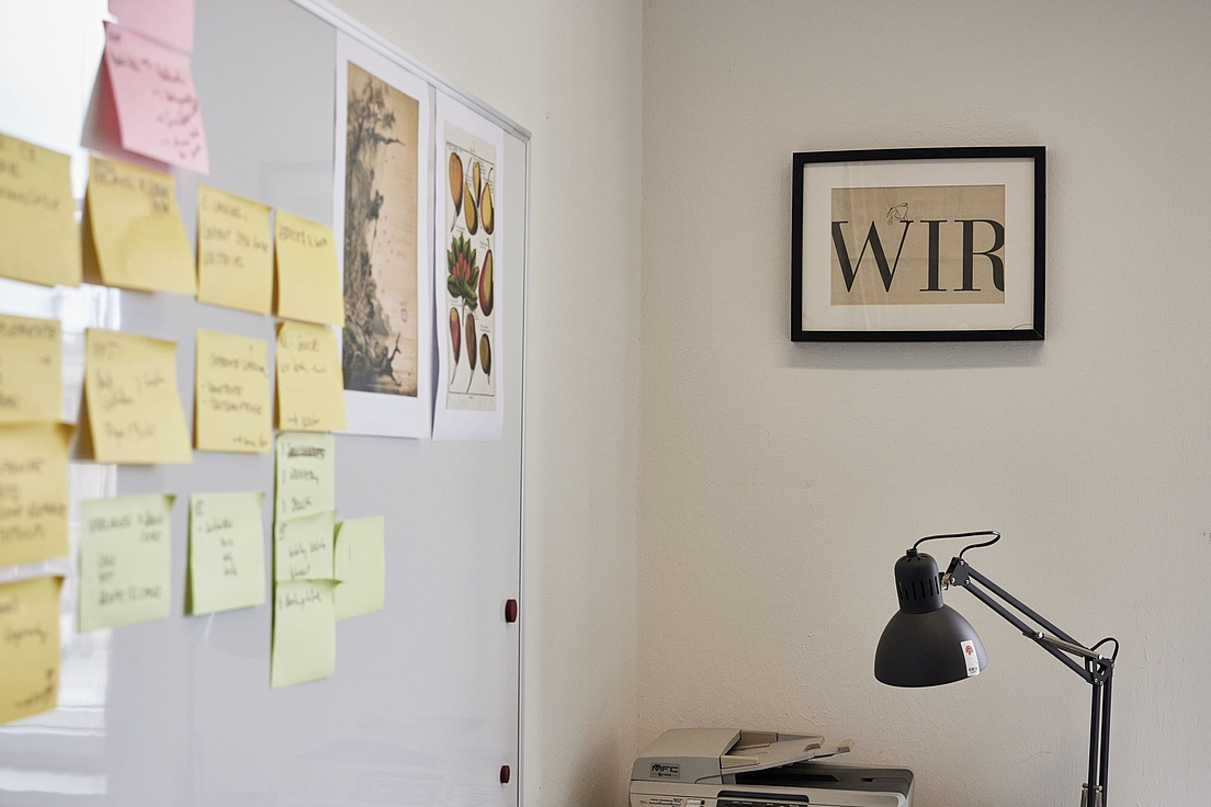 Desk with a lamp, a frame with the inscription "We" and Post-it notes.