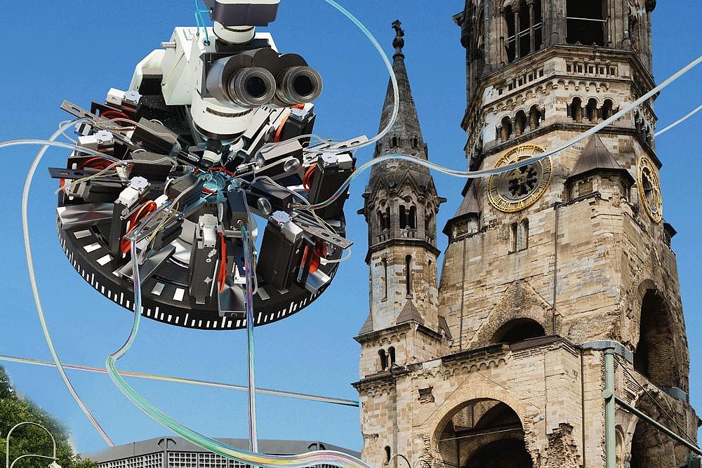Ein Mikroskop schwebt in der Luft vor der Gedächtniskirche in Berlin