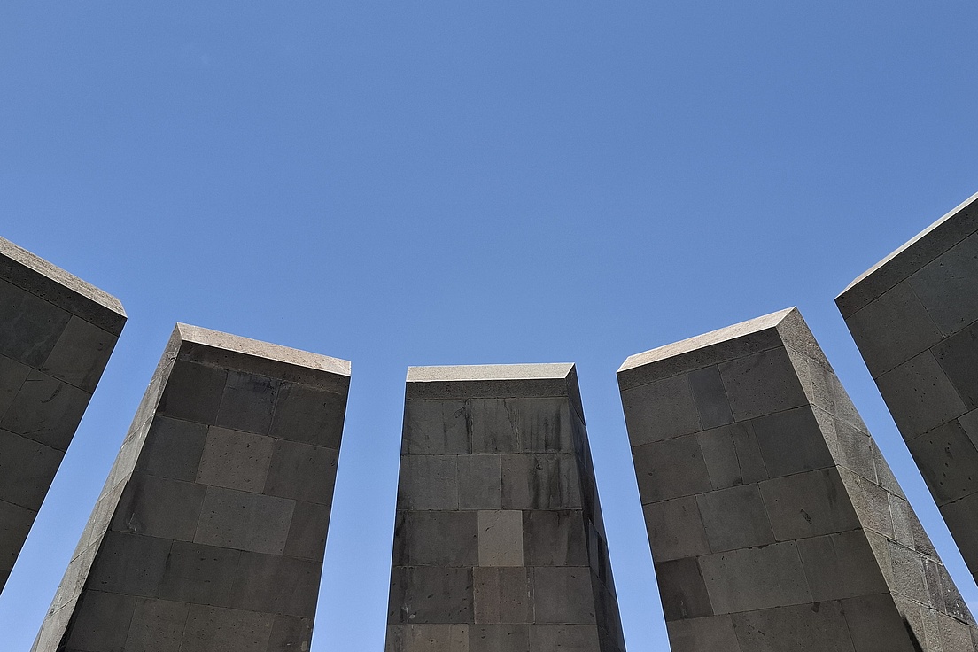 ein blauer Himmel im oberen Teil des Bildes. Im unteren Teil fünf glatte Steinblöcke.